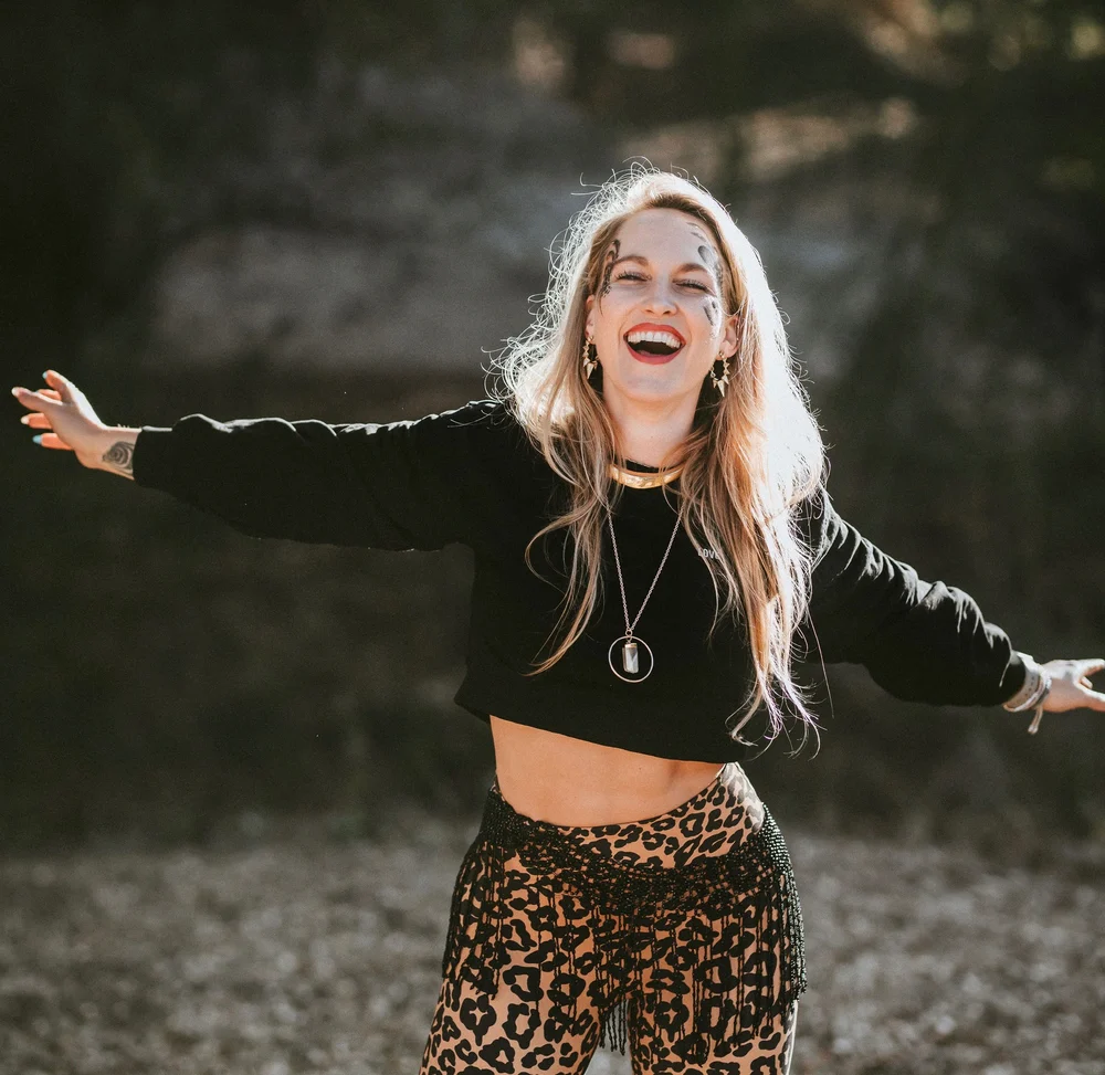 A woman laughing with her arms wide open
