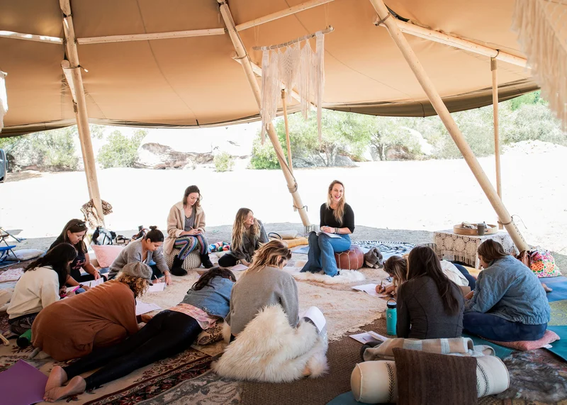 Women gathered in a sunlit tent